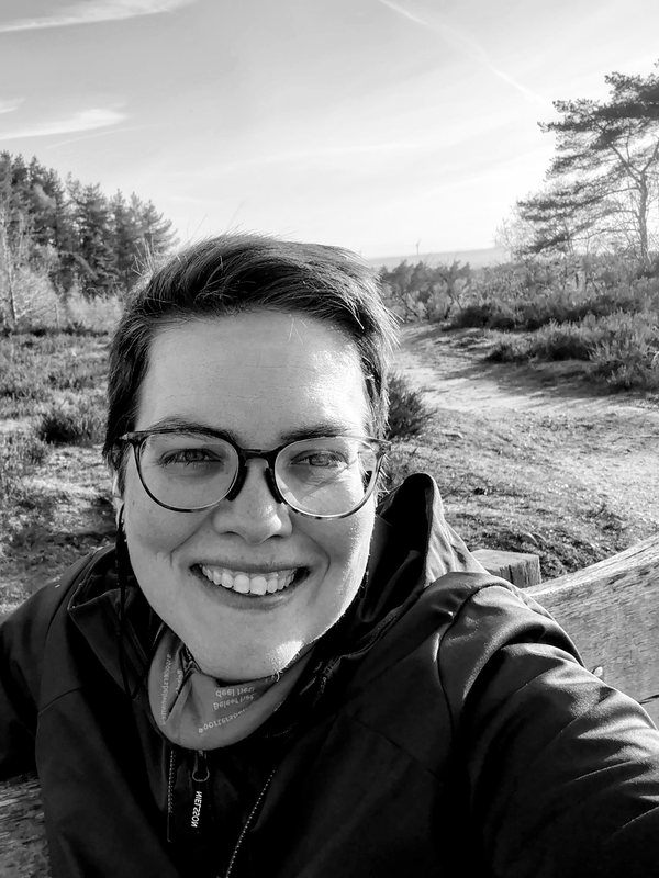 Cindy lachend op een bankje op de heide